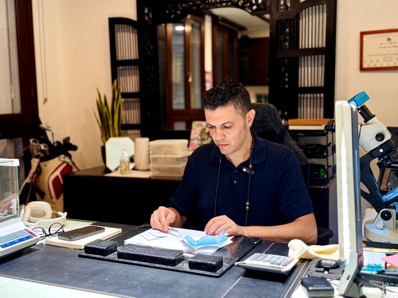 Bàn làm việc tại văn phòng SYJ Singapore với cân điện tử, kính soi và giấy kiểm định